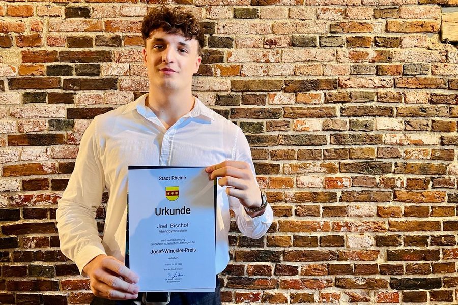Joel Bischof hält die Urkunde des Josef-Winckler-Preises der Stadt Rheine in den Händen